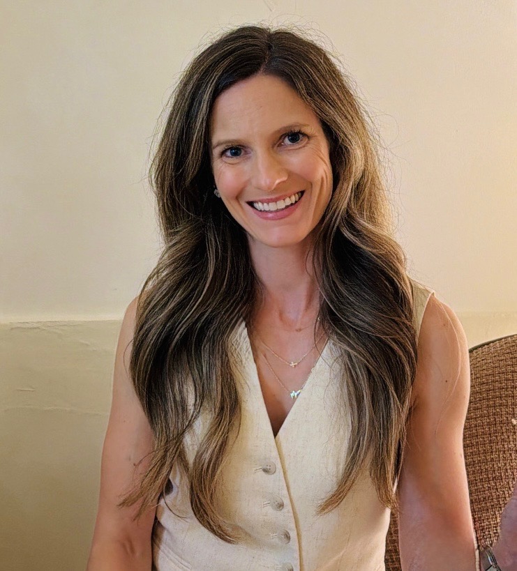 Lauren Smith smiling in a bright home kitchen, wearing a linen shirt